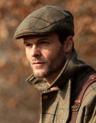 Abraham Moon Tweed Alfred Flat Cap in Castleton Green, on model
